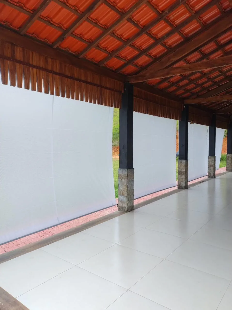 Toldo cortina em lona branca fechando a varanda de uma casa